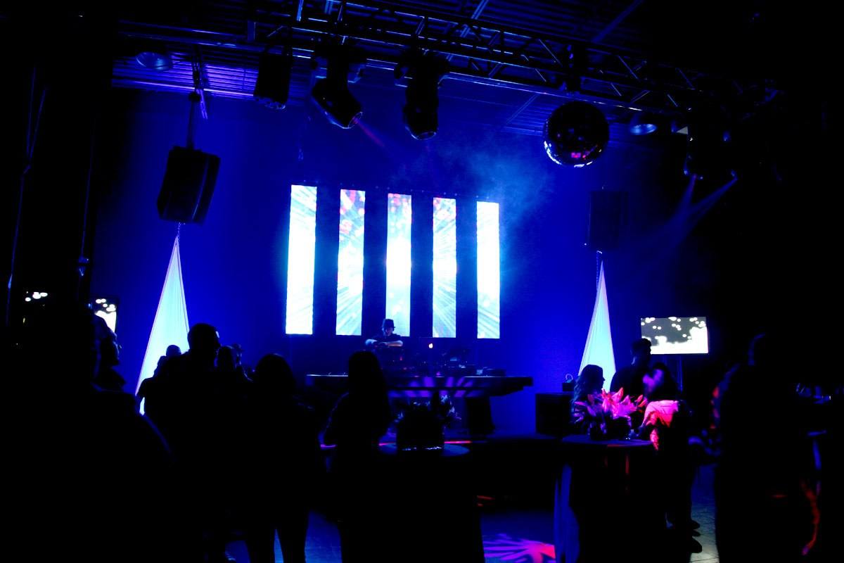 Club room in blue with the booth lit and the floor filling