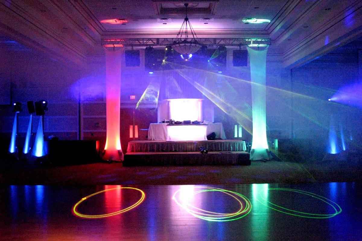 Dance floor under coloured gobo rings with the booth lit behind